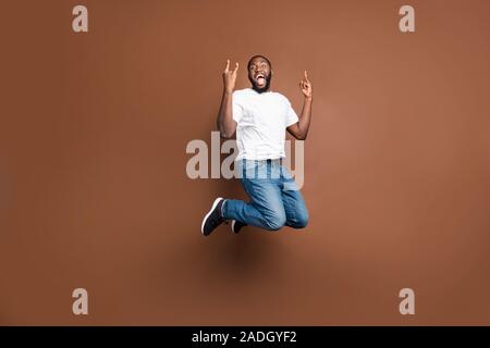 Volle Länge Körper Größe Foto fröhliche, positive aufgeregt Crazy and Trendy Kerl in Jeans Denim weisses T-Shirt, das Sie doppelt rock Zeichen Stockfoto