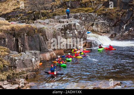 Gruppe von Jugendlichen Ausbildung in Kajaks am Fluss Etive fällt, Glencoe, Scottish Highlands, Schottland, UK im März Stockfoto