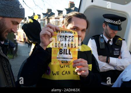 Streatham, London, UK. 04 Dez, 2019. Aussterben Rebellion sind Summen um die Kampagne Busse heute Morgen (04.12.19) und anspruchsvollen Klima- und ökologischen Notstand ist ganz oben auf der Tagesordnung dieser Wahl. 6 Aktivisten wie die Bienen sind gekleidet in streatham an der Bibliothek Dem Bus, eine Person auf den Bus geklebt ist. Der Protest, der Name "Biene - über Politik" gehen, wird durchgeführt, um Politiker von den unersetzlichen Verlust der biologischen Vielfalt, ist eine direkte Folge der schlechten, unverantwortliche Politik erinnern. Credit: Gareth Morris/Alamy leben Nachrichten Stockfoto