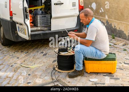 Telefontechniker von Faro, der Glasfaserkabel befestigt und verlegt. Faro, Ostalgarve Portugal. Stockfoto