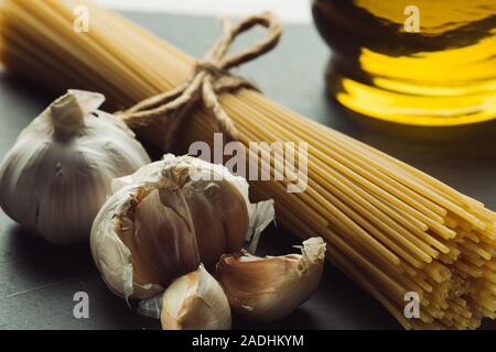 Nahaufnahme von Knoblauchzehen in der Nähe von Rohstoffen italienische Pasta Stockfoto