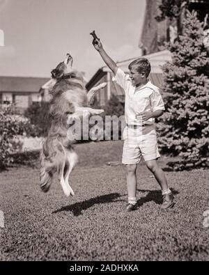 1930er Jahre jugendliche Junge tragen weiße SHORTS UND SHIRT VERLOCKEND ROUGH COLLIE HUND SPRUNG FÜR HUND KEKS BEHANDELN IN SUBURBAN VORGARTEN - d 3922 HAR 001 HARS LIFESTYLE GESUNDHEIT BEHANDELN HOME LEBEN KOPIEREN RAUM FREUNDSCHAFT IN VOLLER LÄNGE MÄNNER RAUHE B&W VERSUCHUNG GLÜCK SÄUGETIERE STÄRKE UND FANGZÄHNE AUFREGUNG AUSSEN COLLIE JUGENDLICHE HÜNDCHEN BEWEGUNGSUNSCHÄRFE KONZEPTIONELLE STILVOLLE BESTER FREUND ROUGH COLLIE HUNDE HUND KEKS JUGENDLICHE SÄUGETIER PRE-TEEN PRE-TEEN BOY ENTSPANNUNG ZWEISAMKEIT SCHWARZ UND WEISS KAUKASISCHEN ETHNIE HAR 001 ALTMODISCH VERLOCKEND Stockfoto