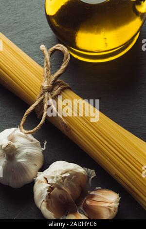 Blick von oben auf die Spaghetti Bündel zwischen Knoblauch und Olivenöl Stockfoto