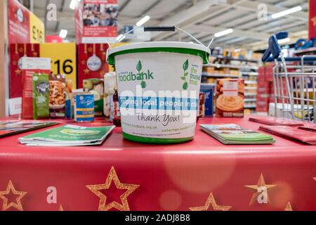 Eine liebe Geld Schaufel für Spenden am Supermarkt Tesco national food bank Kollektion für Trussell Vertrauen foodbank Stockfoto