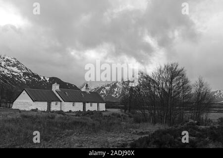 Blackrock Cottage mit buachaille Etiv Mor im Hintergrund, Rannoch Moor, Glencoe, Scottish Highlands, Schottland, UK im März - Schwarz und Weiß Stockfoto