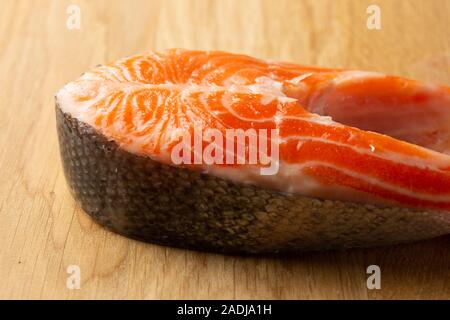 Holztisch mit Stück roter Fisch Stockfoto