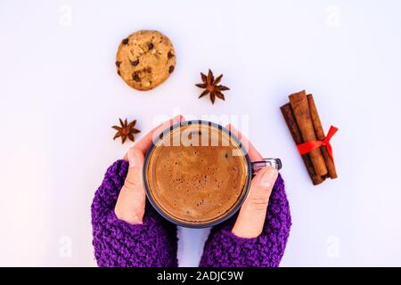 Weibliche Hände, die heiße Schokolade auf einem weißen Hintergrund. Stockfoto