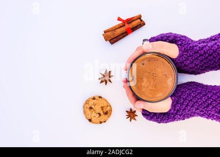 Weibliche Hände, die heiße Schokolade auf einem weißen Hintergrund. Stockfoto