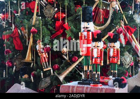 Soldat Nußknacker hölzerne Statue stand vor der geschmückten Weihnachtsbaum auf ein altes Buch Stockfoto