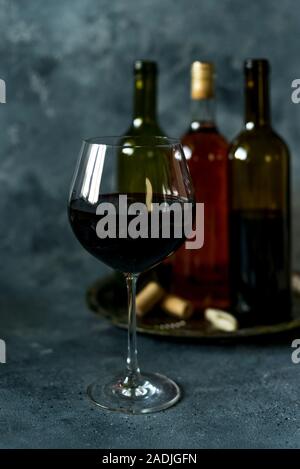 Rotwein. Flasche und Glas Rotwein. Vintage Style. Rotwein auf einem schwarzen Hintergrund. Design mit Platz für Ihren Text. Stockfoto