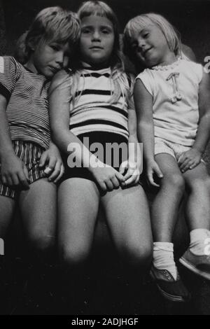 Feine schwarze und weiße Kunst Fotografie von den 1970er Jahren von drei Kinder auf dem Boden Stockfoto