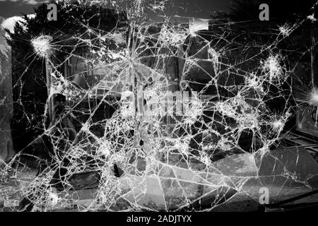 Nahaufnahme von zerbrochenem Glas. Defekter Bildschirm unschärft. Zerschmetternde Glasscheiben. Auto windsiled gebrochene Textur. Weichfokus. Stockfoto