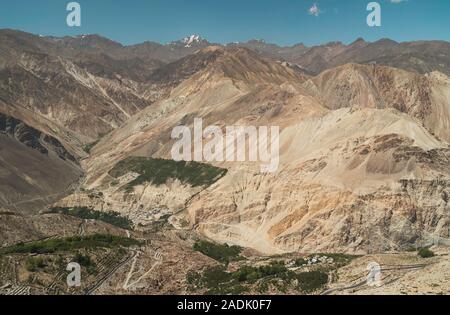 Blick über den Spiti Tal mit Blick auf die Gipfel des Himalaya, ein kleines Dorf und Oase der Bäume von Nako, Himachal Pradesh, Indien gesehen. Stockfoto