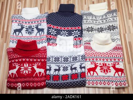 Verschiedene gestrickt Weihnachten rollkragen Strickjacken und Pullover mit Nordic Ornament auf Holz- Hintergrund gefaltet Stockfoto