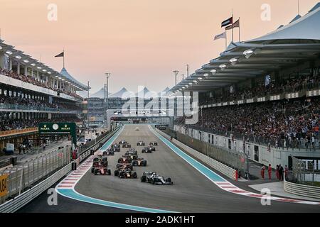 Treiber nehmen Sie die erste Abzweigung während der ersten Runde der Abu Dhabi F1 Grand Prix auf dem Yas Marina Circuit in Abu Dhabi. Stockfoto