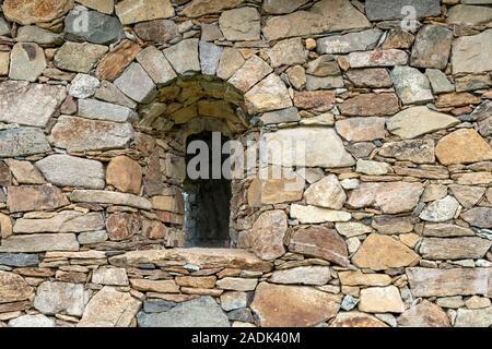 Bogenförmige Fenster in der Mauer aus Stein Stockfoto