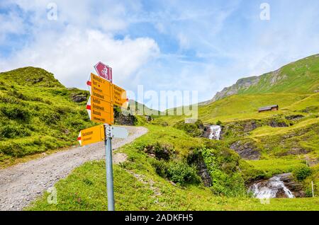 Gelbe touristische Zeichen auf dem Weg von Grindelwald zum Bachalpsee See in der Schweiz. Informationen Zeichen, Distanzen und Richtungen der Wanderer in den Schweizer Alpen. Sommer Alpine Landschaft. Stockfoto