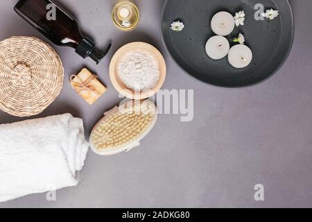 Spa noch Leben mit verschiedenen Körper- und Hautpflege Essentials und Schüssel mit schwebenden Kerzen Stockfoto