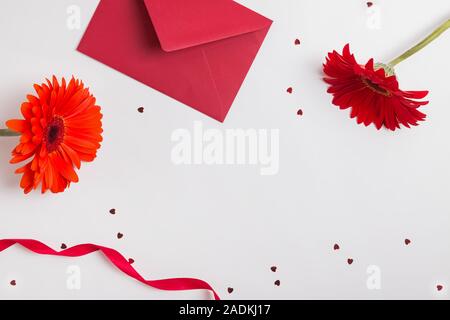 Rote Blumen, Umschlag, Farbband und sternförmigen Konfetti auf weißem Hintergrund Stockfoto