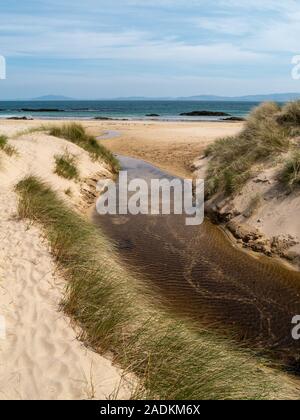 Stream läuft zwischen Sanddünen mit Marram Gras auf Balnahard Strand, Insel Colonsay in der Inneren Hebriden, Schottland Stockfoto