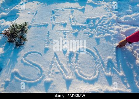 Lassen Sie es schneien Schreiben auf frischen Schnee von Frau draußen gemacht. Winter frostige Wetter Stockfoto