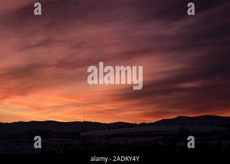 Schönen bunten Sonnenuntergang über Banska Bystrica, Slowakei. Winter Snowy Valley und dramatischen Himmel. Kopieren Sie Platz. Stockfoto