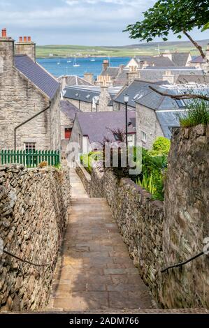 Gesetz Lane ist einer der steilen Gassen hinunter auf der Uferpromenade am Lerwick. Insel Bressay im Hintergrund. Stockfoto