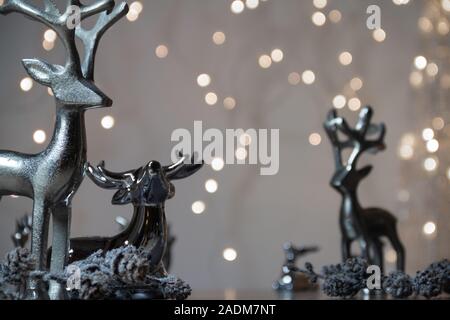 Silber Rentiere und wunderschöne Lichterketten in den Hintergrund. Glänzende Lichter und Schneeflocken. Vorderansicht Weihnachtsdekoration. Kopieren Sie Platz für Text Stockfoto