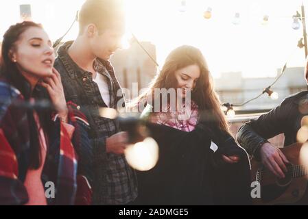 Spielt die Musik. Es ist auf dem Dach. Die Gruppe der Freunde Urlaub am sonnigen Herbsttag Stockfoto