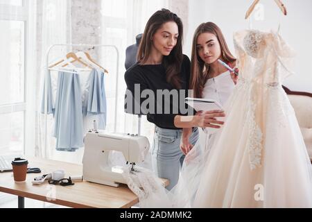 Hinweise einige Korrekturen. Der Prozess der Montage das Kleid im Studio von Hand gestaltete Kleidung Stockfoto