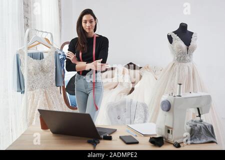 Stolzer Besitzer. Weibliche Mode Designer arbeitet auf der neuen Kleidung in der Werkstatt Stockfoto