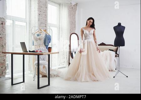 Portrait auf der sauberen, weißen Raum. Der Prozess der Montage das Kleid im Studio von Hand gestaltete Kleidung Stockfoto