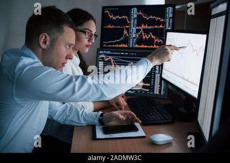 Die Planung des Projektes. Mannschaft der Börsenmakler sind ein Gespräch in einem Büro mit mehreren Bildschirmen Stockfoto