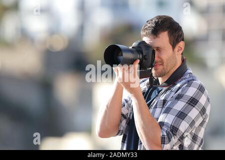 Man Fotos, die mit einer DSLR-Kamera in einer ländlichen Stadt Stockfoto
