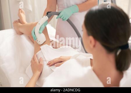 Junge Frau mit Laser Haarentfernung auf ihre wunderschönen Beine Stockfoto