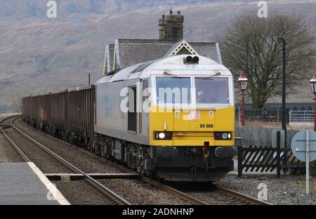 Klasse 60 Typ 5 Diesellok in Silber Lackierung schleppen Gips Zug durch Ribblehead Station auf Carlisle Railway Line 4. Dezember 2019 vereinbaren. Stockfoto