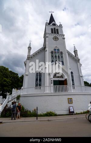 Blick auf St. Ann's Kirche von der Main Street View mit Touristen, Mackinac Island, Michigan, USA. Stockfoto