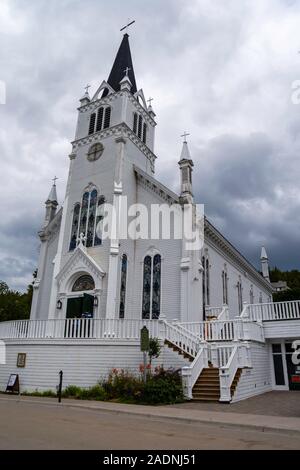 Blick auf St. Ann's Kirche von der Main Street View mit Touristen, Mackinac Island, Michigan, USA. Stockfoto