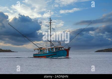 Blau Krabbenkutter auf dramatische Himmel Stockfoto