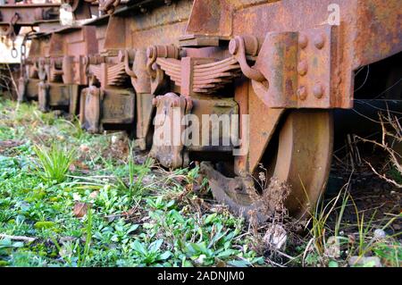 Räder und Federn der alten vergessen Zug auf den Gleisen. Ein rostiger Güterwagen. Stockfoto