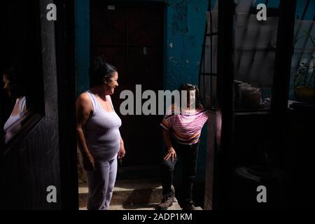 November 29, 2019, Caracas, Miranda, Venezuela: Aura und ihre Nachbarn Marianna über ihre Tage sprechen... Aura Graciela Sarmiento, Alter 56, und ihr Mann Jose Alberto Abreu, Alter 62, habe keine fliessendes Wasser in Ihrem Haus in 4 Jahren. Aura arbeitet in ein Geschäft mit Büromöbeln und Jose ist ein Mechaniker. Sie leben in der Nähe von Altos de Lidice in Caracas Venezuela. Altos de Lidice ist ein historisches Chavista Nachbarschaft. Aber Aura ist pro-Opposition, und hat nie die Chavez Regime unterstützt, obwohl sie in diesem pro lebten - Chavez/Maduro barrio ihr ganzes Leben. Sie können es sich nicht leisten, Stockfoto