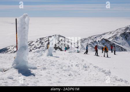 Skifahrer und Snowboarder auf einer roten Skipiste auf dem Pico Veleta Berg in der Sierra Nevada, in der Nähe von Granada, Andalusien, Spanien Stockfoto