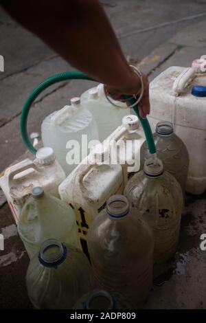 Caracas, Miranda, Venezuela. 29 Nov, 2019. Aura befüllen das Wasser contaners mit dem Wasser aus dem Haus ihrer Schwester. Aura Graciela Sarmiento, Alter 56, und ihr Mann Jose Alberto Abreu, Alter 62, habe keine fliessendes Wasser in Ihrem Haus in 4 Jahren. Aura arbeitet in ein Geschäft mit Büromöbeln und Jose ist ein Mechaniker. Sie leben in der Nähe von Altos de Lidice in Caracas Venezuela. Altos de Lidice ist ein historisches Chavista Nachbarschaft. Aber Aura ist pro-Opposition, und hat nie die Chavez Regime unterstützt, obwohl sie in diesem pro lebten - Chavez/Maduro barrio ihr ganzes Leben. S Stockfoto