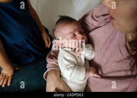 Mutter tragen rosa Shirt liebevoll hält neugeborenes Baby Stockfoto