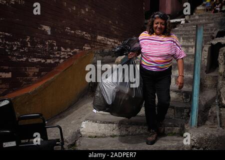 Caracas, Miranda, Venezuela. 29 Nov, 2019. Aura setzt sie Wasser mit ihrem Mann und ihrem Sohn sammeln. Aura Graciela Sarmiento, Alter 56, und ihr Mann Jose Alberto Abreu, Alter 62, haben nicht läuft Wasser in Ihrem Haus in 4 Jahren hatte. Aura arbeitet in ein Geschäft mit Büromöbeln und Jose ist ein Mechaniker. Sie leben in der Nähe von Altos de Lidice in Caracas Venezuela. Altos de Lidice ist ein historisches Chavista Nachbarschaft. Aber Aura ist pro-Opposition, und hat nie die Chavez Regime unterstützt, obwohl sie in diesem pro lebten - Chavez/Maduro barrio ihr ganzes Leben. Sie kann Aff Stockfoto