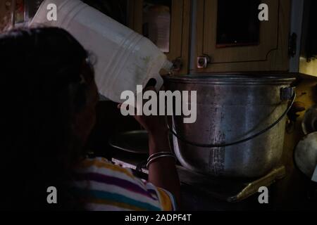 Caracas, Miranda, Venezuela. 29 Nov, 2019. Aura kocht das Wasser, die sie von ihrer Schwester nach Hause sammelt, so dass es sicher für drining. Aura Graciela Sarmiento, Alter 56, und ihr Mann Jose Alberto Abreu, Alter 62, haben nicht läuft Wasser in Ihrem Haus in 4 Jahren hatte. Aura arbeitet in ein Geschäft mit Büromöbeln und Jose ist ein Mechaniker. Sie leben in der Nähe von Altos de Lidice in Caracas Venezuela. Altos de Lidice ist ein historisches Chavista Nachbarschaft. Aber Aura ist pro-Opposition, und hat nie die Chavez Regime unterstützt, obwohl sie in diesem pro lebten - Chavez/Maduro barrio h Stockfoto