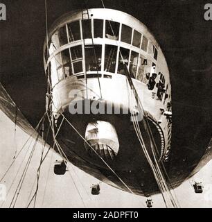 Ein historisches Foto des Graphen, Zeppelin, der Pilot an den Kontrollen und Passagiere und Besatzungsmitglieder aus den Fenstern. Es wurde von fünf Maybach Motoren angetrieben. 772 Meter lang, 100 Meter breit, 107 Tonnen Verdrängung. Er flog um die Welt in 1929. Stockfoto