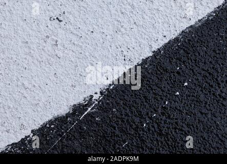 Nahaufnahme einer verputzt und raue Wand in weiß und schwarz lackiert. Hochauflösende full frame strukturierten Hintergrund. Stockfoto