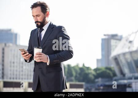 Ernsthafte Geschäftsmann gehen, um einen Anruf zu tätigen Stockfoto