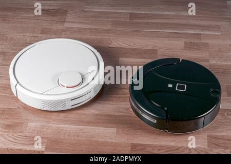 Zwei verschiedene Roboter Staubsauger. Konzept Auswahl Haushaltshelfer. Moderne smart Appliance für Reinigung Haus. Stockfoto